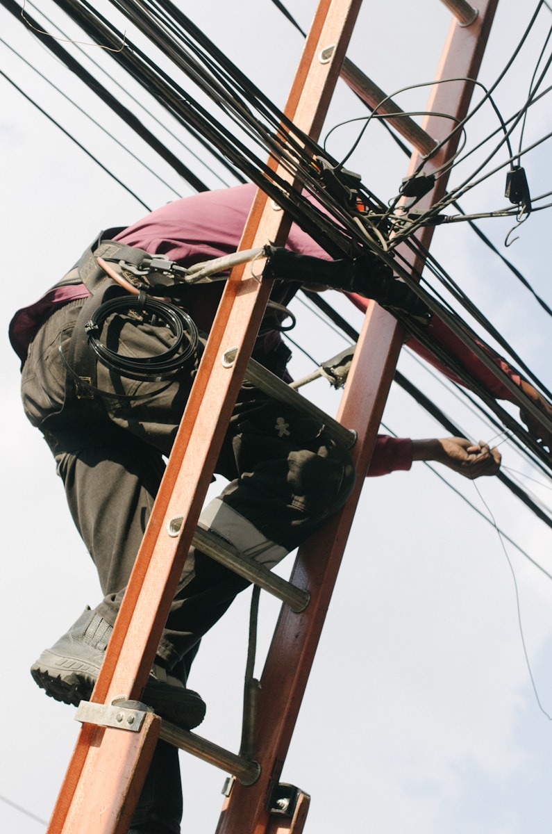 man on top of electrical wires